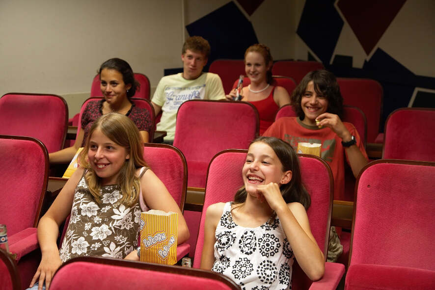 Deelnemers taalreis Duitsland zitten in cinéma, kijken film en lachen