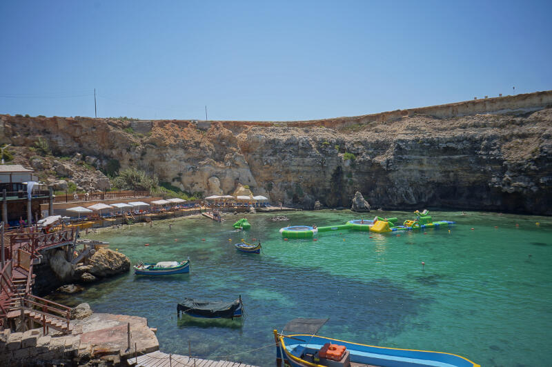 Een blauwe baai in Malta met bootjes en een waterkasteel tijdens een summer camp English