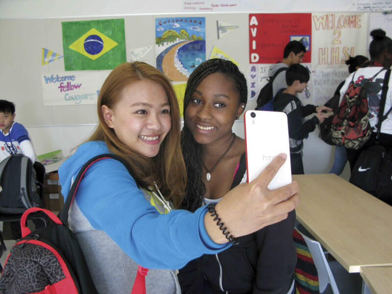 Des filles prennent un selfie dans une salle de classe colorée lors d'un séjour linguistique Angleterre.