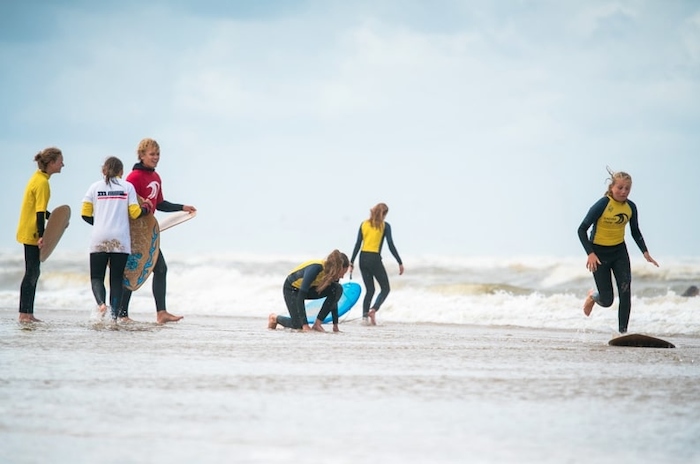 Jongeren maken zich klaar om te surfen op surfkamp herfstvakantie