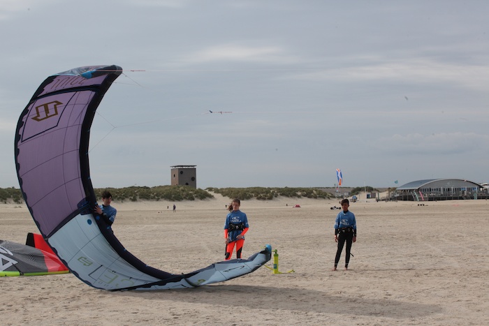 Jongen en meisje met kite op het strand tijdens het kitesurfkamp in Zeeland.