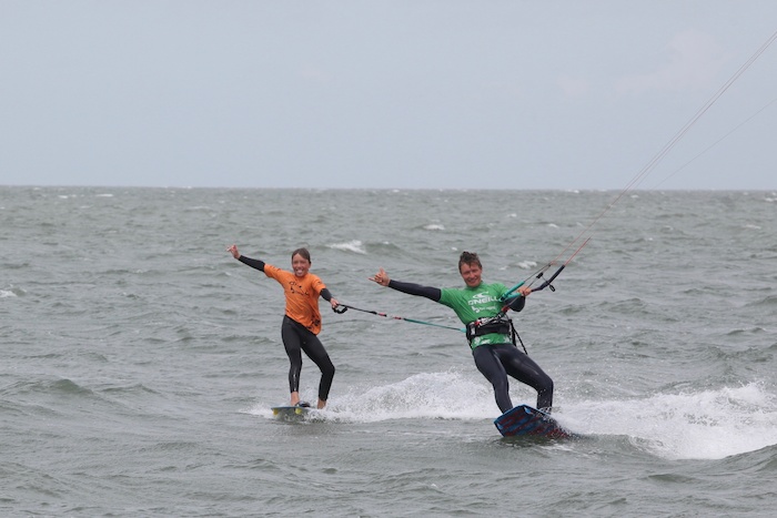 Jongens aan het kitesurfen op de zee tijdens het kitesurfkamp in Zeeland.
