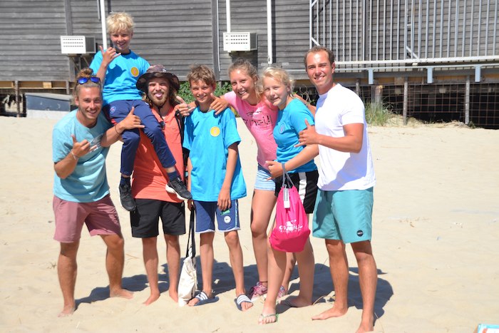 Kinderen poseren met hun begeleiders op het surfkamp in Zeeland.