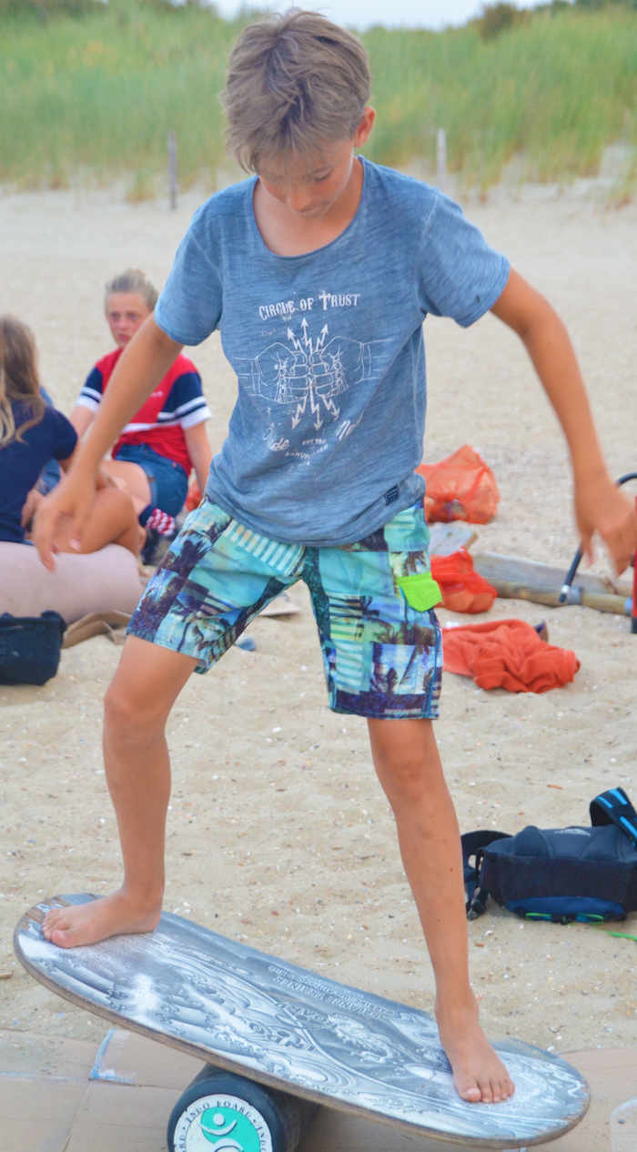 Een jongen oefent zijn evenwicht op het surfkamp in Zeeland.