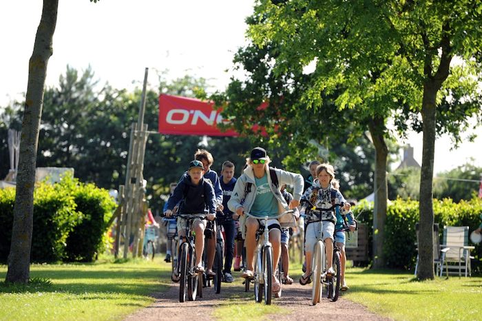 Jongeren gaan tussen het surfen door op uitstap met de fiets tijdens het surfkamp