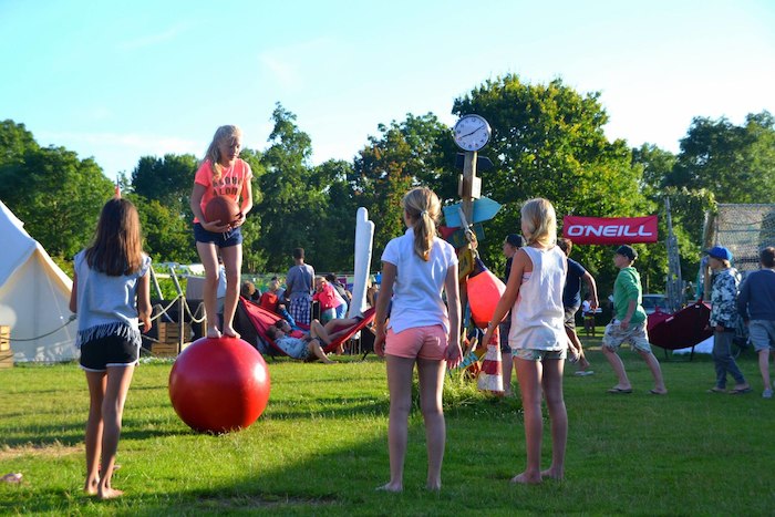 Jongeren en kinderen leren hun evenwicht bewaren op het evenwichtsparcours tijdens het surfkamp