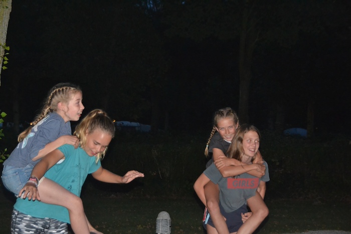 Vier meisjes tijdens het avondspel op surfkamp in Zeeland.