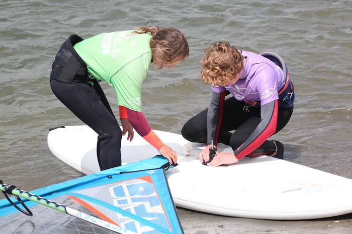Jongeren tijdens de voorbereiding tijdens het windsurfkamp in Zeeland.