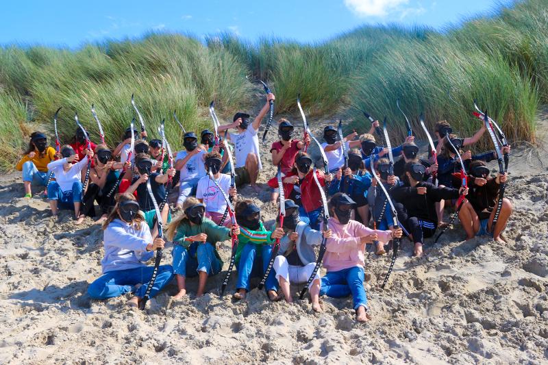 Groep kinderen met pijl en boog op watersportvakantie Nederland