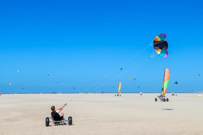 Jongen blowkart op het strand tijdens een watersportvakantie Nederland