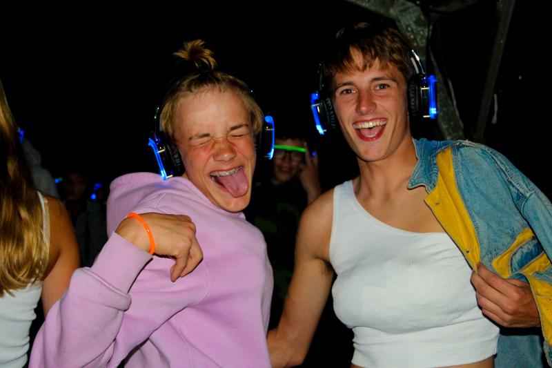 meisjes steken tong uit tijdens de silent disco tijdens surfkamp zomervakantie