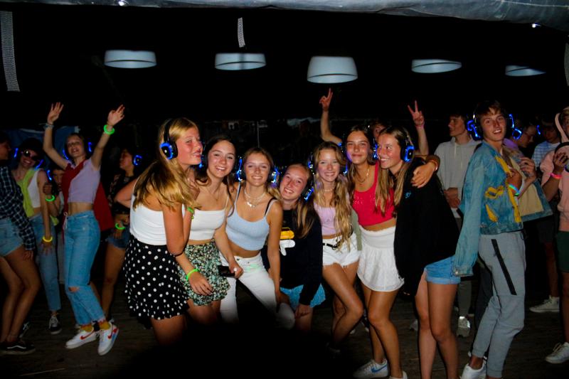 groep meisjes poseren en dansen tijdens de silent disco tijdens surfkamp zomervakantie