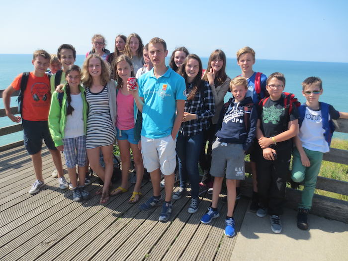 Groep op taalreis Engels poseert voor de camera bij zee.