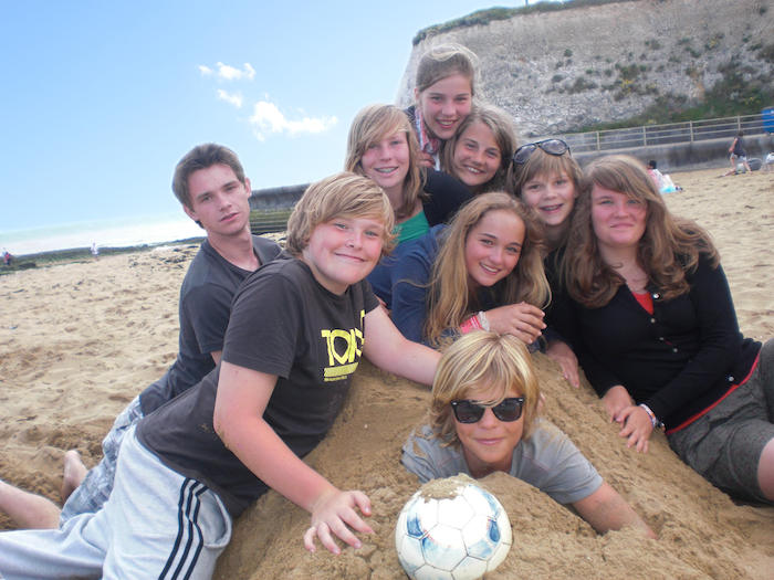 Kinderen spelen in het zand op strand tijdens zomerkamp . 