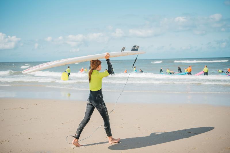 Meisje loopt het water in tijdens surfkamp Schoorl