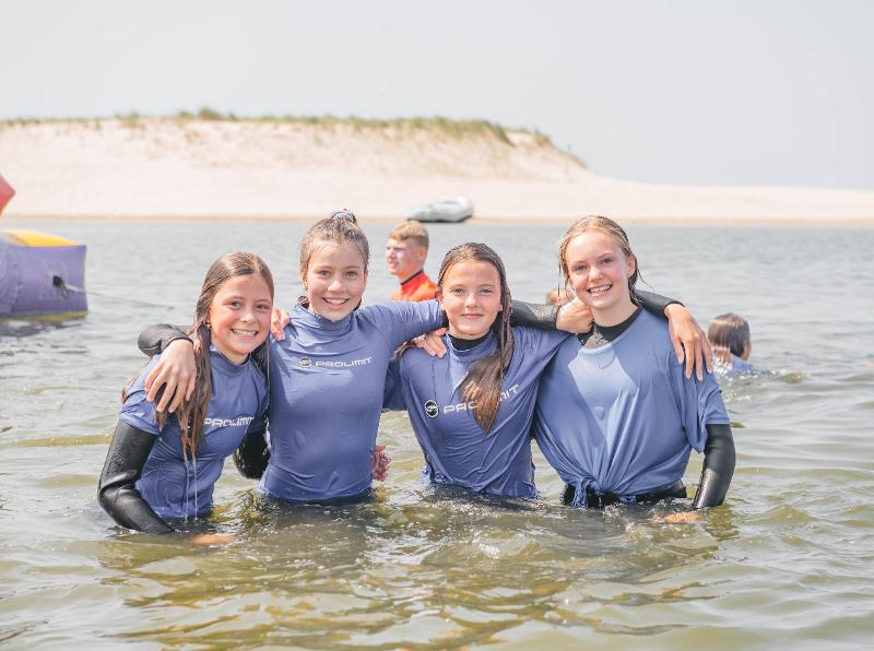Meisjes lachen voor de foto op kitesurfkamp Nederland