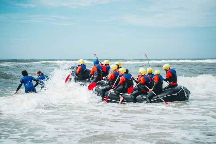 Jongeren raften op zee tijdens het watersportkamp in Noord-Holland.