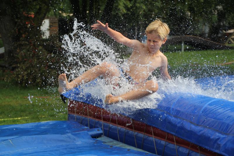 jongen glijdt van waterglijbaan tijdens een vakantie voor jeugd