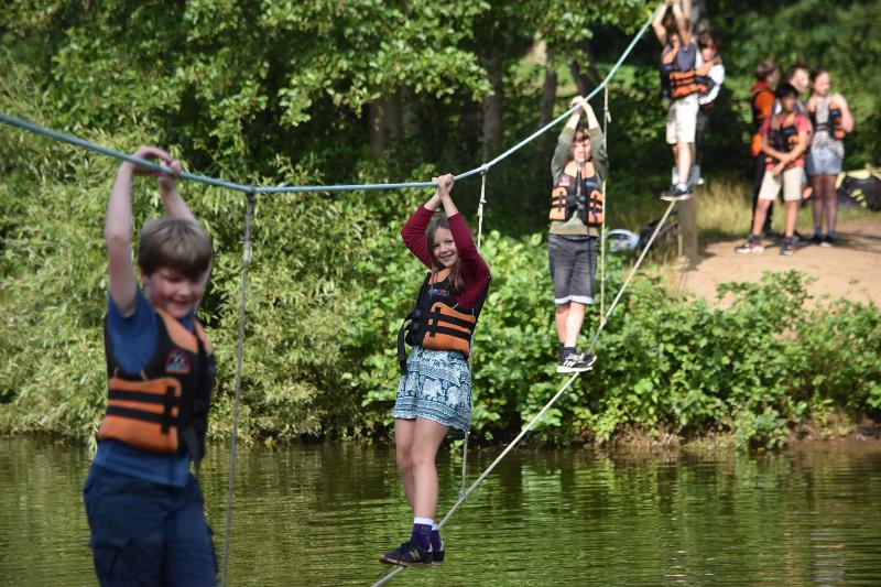 jongeren lopen over touw boven water tijdens een jongerenvakantie nederland