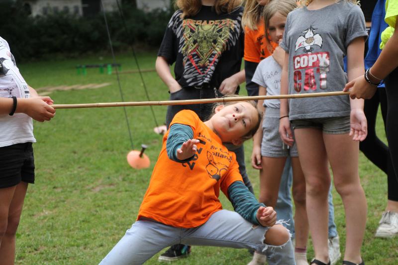 meisje loopt onder limbostok door tijdens het limbodansen op een jongerenvakantie nederland