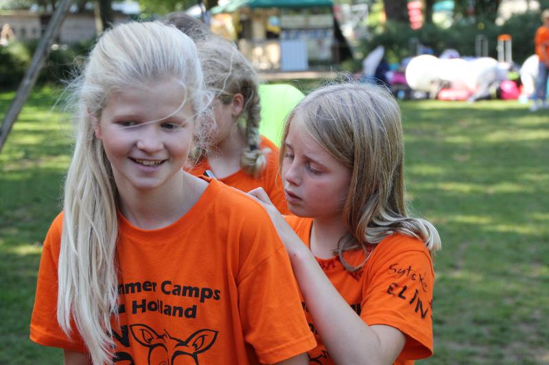 meisje schrijft iets op de rug van een vriendin tijdens een jongerenvakantie nederland