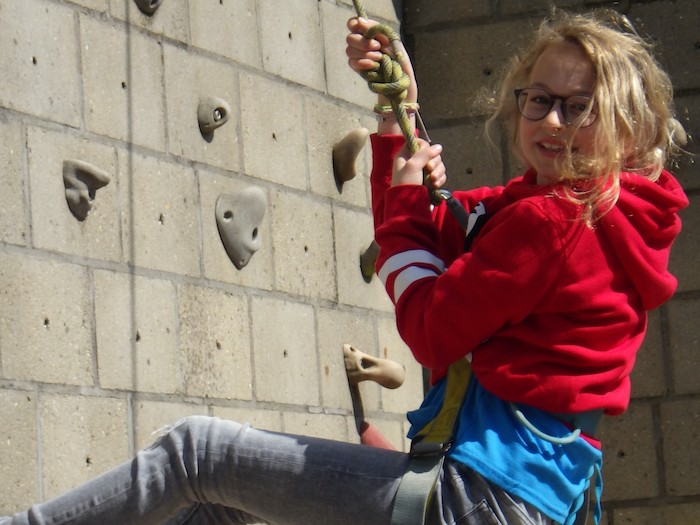 Meisje is aan het muurklimmen en poseert voor de foto