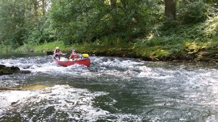 Kinderen varen rivier af in kano tijdens outdoor kamp