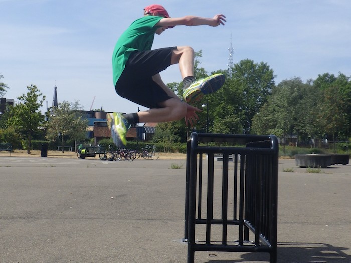 Een jongen springt over een obstakel op free running zomerkamp in Gelderland.