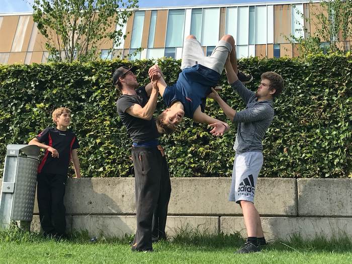 Een jongen maakt een salto achterwaards bij het free running zomerkamp in Gelderland.