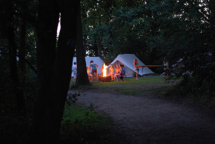 Blik op flikkerend zomerkampvuur in donkere nacht. 