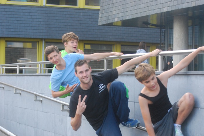 Jongens poseren met hun stoere begeleider tijdens het free runningkamp tijdens de zomervakantie