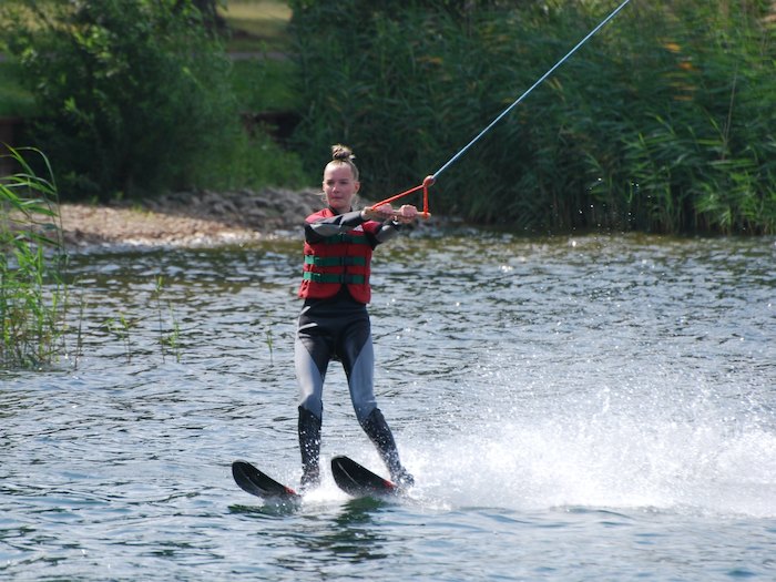 Een meisje op waterskis op wakeboardkamp in Gelderland tijdens de zomer.