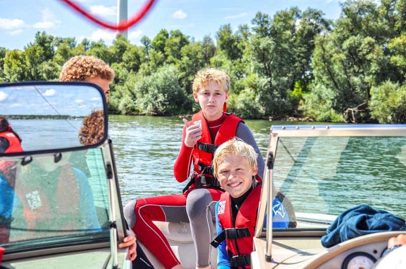 Jongens genieten op een boot tijdens een van onze kinderreizen