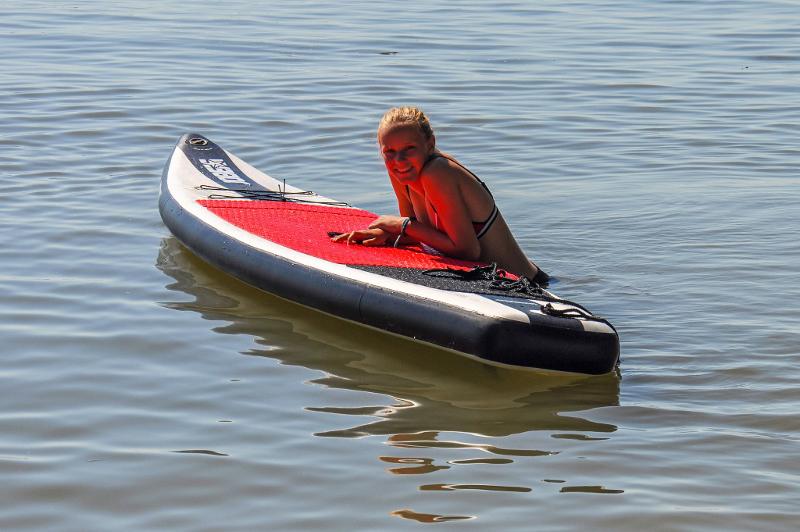 Meisje ligt op board tijdens watersportkamp Zuid-Holland