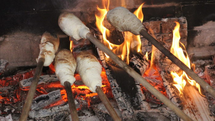 Zicht op marshmallows die roosteren aan het kampvuur op zomerkamp Nederland.