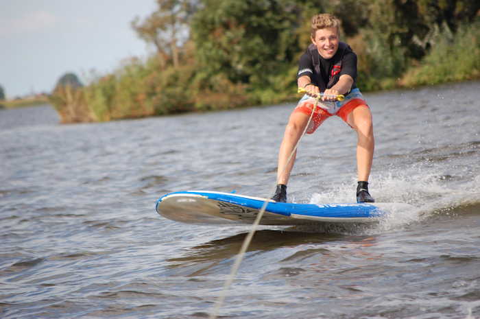Jongen wakeboardt op surfkamp 