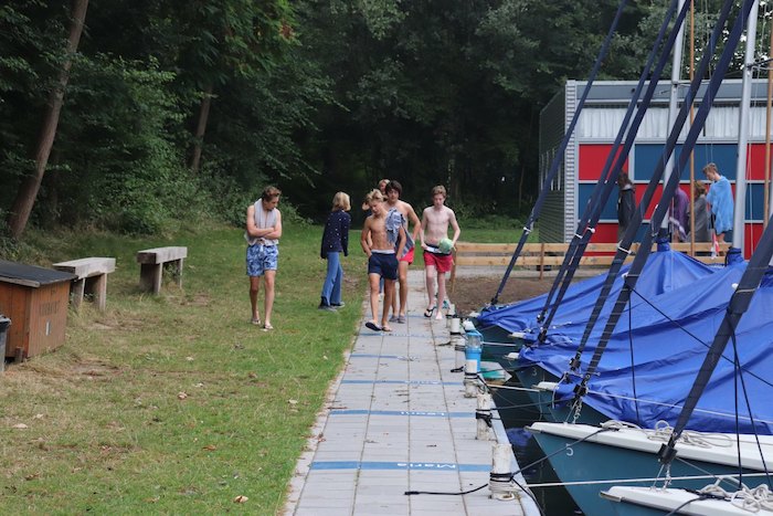 Jongens maken zich klaar om te gaan zwemmen in het meer tijdens het zeilkamp