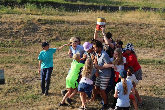 Kinderen spelen samen met hun begeleiders een groepsspel tijdens het zeilkamp