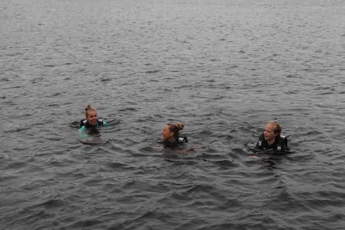 Meisjes zwemmen in het meer tijdens het zeilkamp