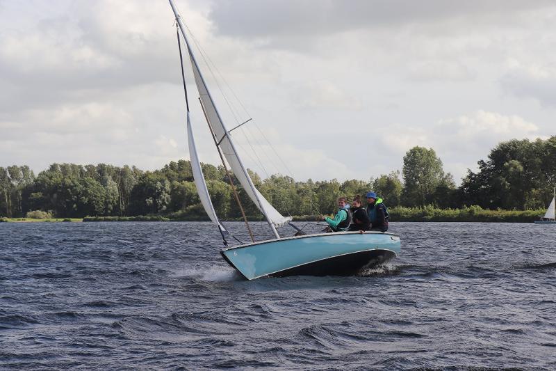 jongens zijn aan het zeilen op een meer met sterke wind op het zeilkamp zomervakantie
