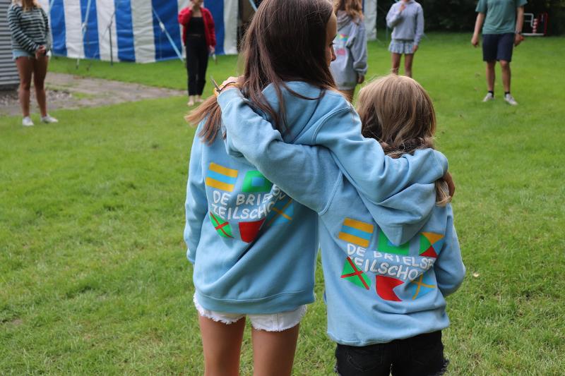 twee meisjes dragen dezelfde hoodie en omhelzen elkaar tijdens zeilkamp kinderen