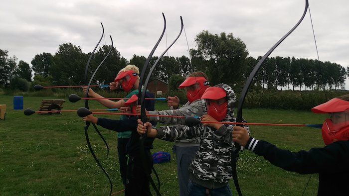 Jongeren oefenen boogschieten tijdens het outdoorkamp in Zuid-Holland.