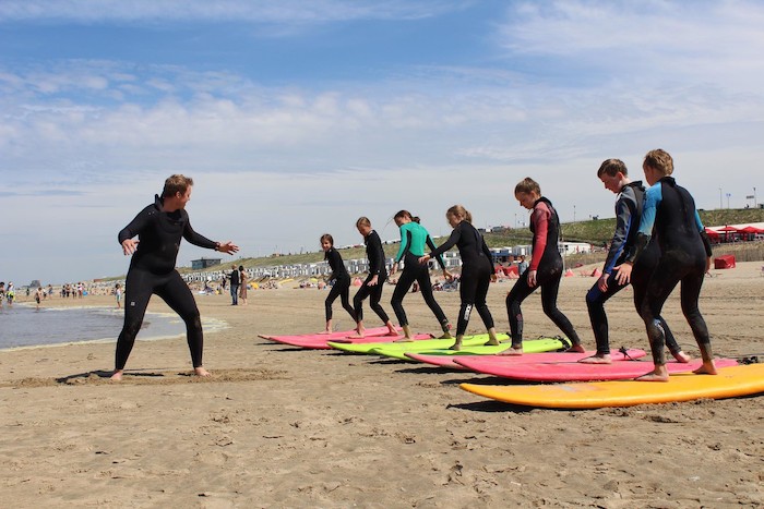 Jongeren krijgen surfles op watersportvakantie Nederland