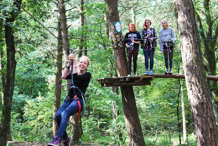 Een meisje glijdt van een zipline tijdens het avonturenkamp in Drenthe