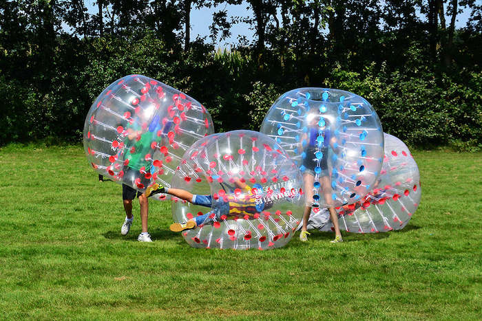 Jeugd op kamp spelen bubbelvoetbal.
