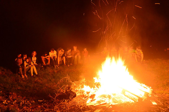 Op zomerkamp 14-16 jaar rond het kampvuur zitten