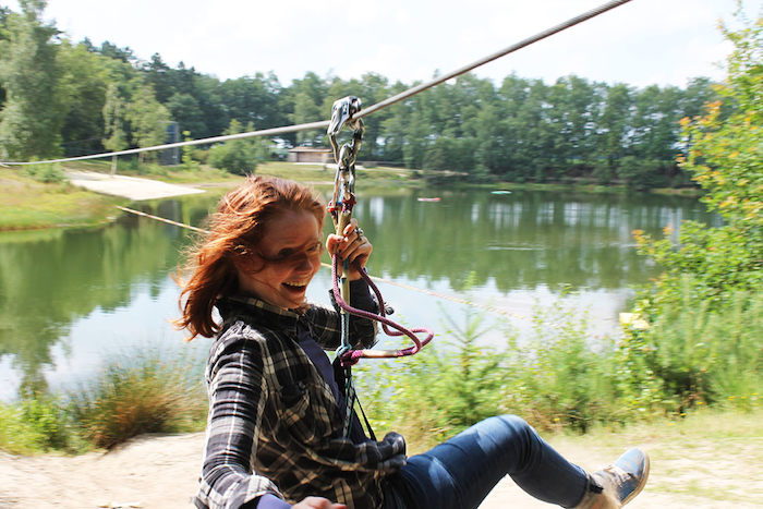 Een meisje glijdt van een zipline tijdens het avonturenkamp in Drenthe