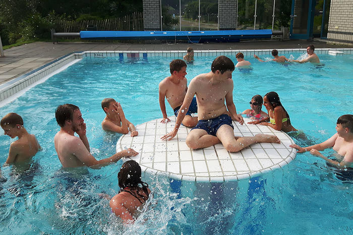 Jongeren zwemmen in een subtropisch zwembad tijdens het zomerkamp in Drenthe