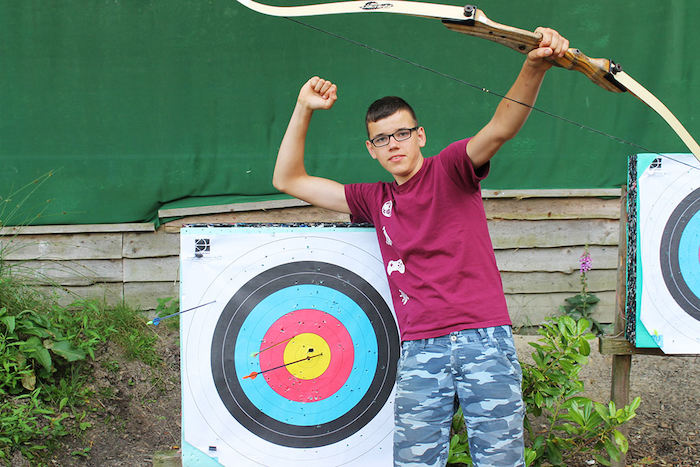 Een jongen schiet met pijl en boog tijdens het gamekamp in Drenthe