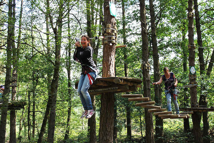 Een meisje glijdt van een zipline tijdens het girl camp in Drenthe